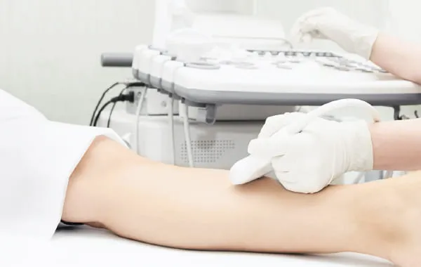Step3 プローブを足に当てて超音波エコー検査を行う技師
