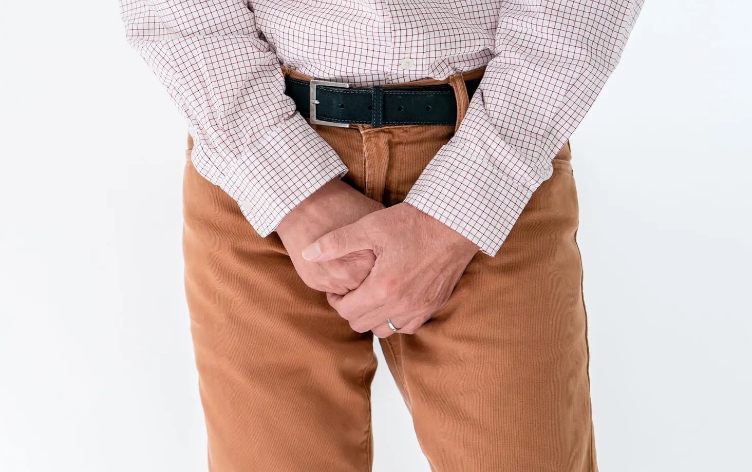 下腹部を押さえる男性の写真。男性の尿もれ対処のイメージ