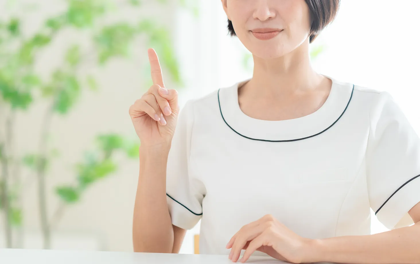 指を立てて説明する白衣の女性
