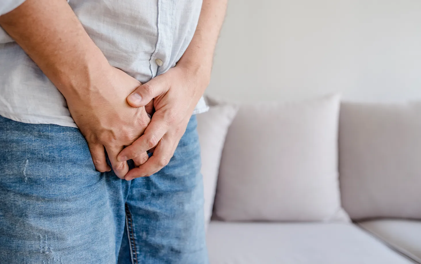 前立腺手術後も尿漏れが残り、股間を押さえる男性