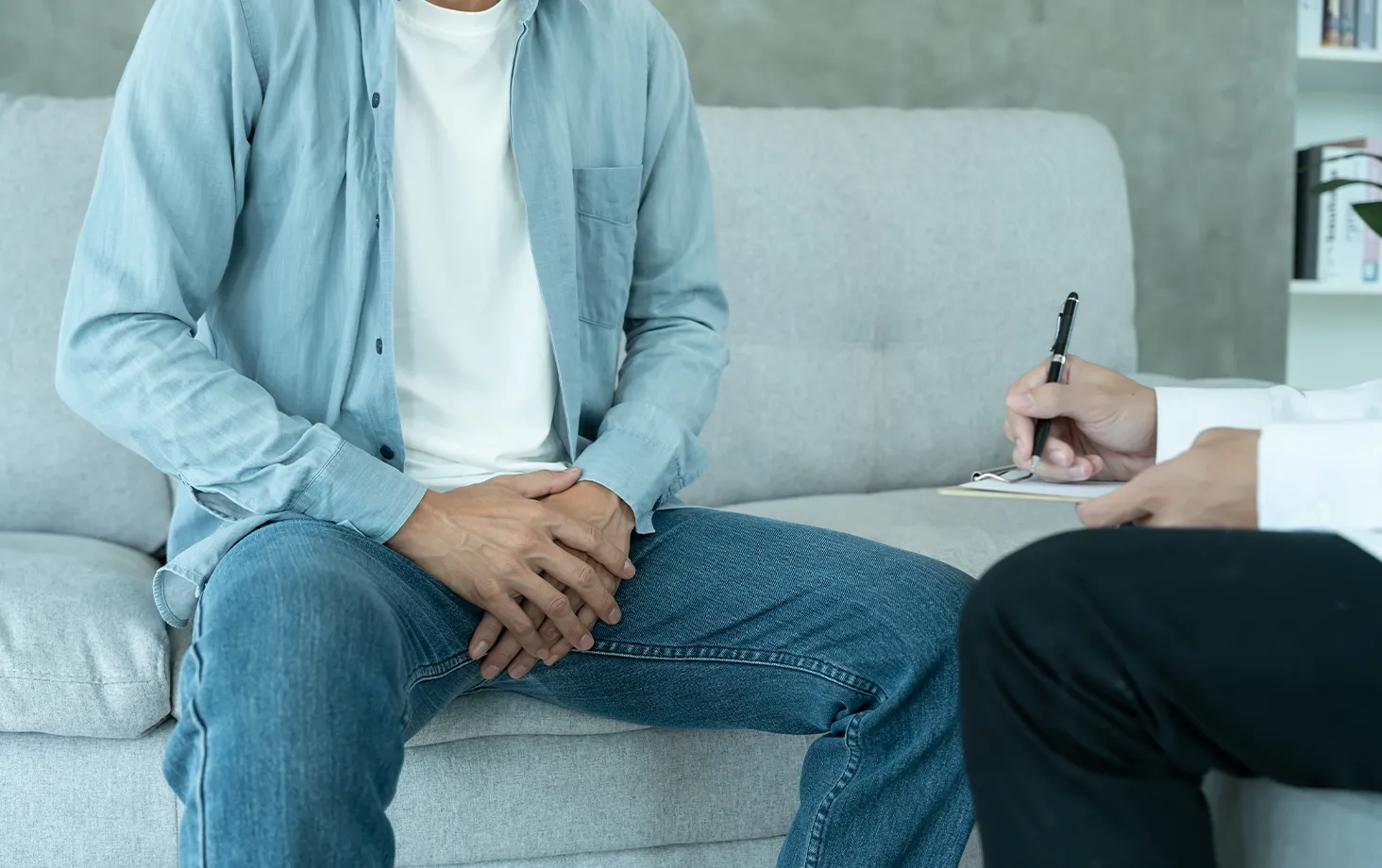 尿漏れの治療相談で問診を受ける男性と、記録する医師