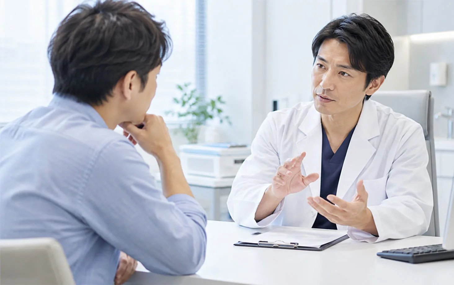 診察室で、医師が患者の話を聞いている
