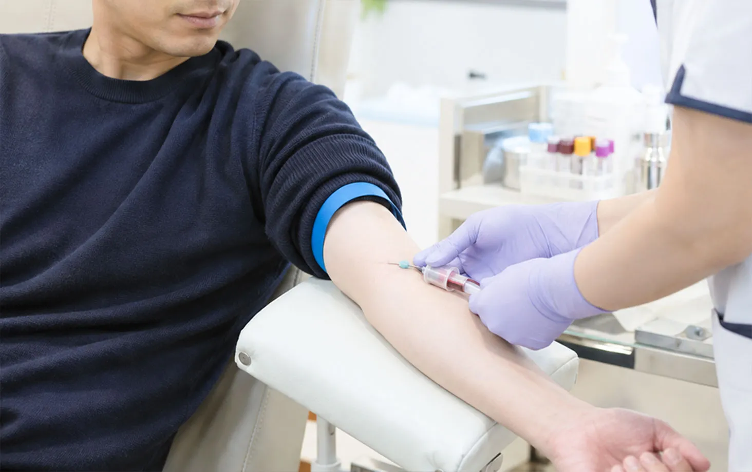 腕から採血されている男性