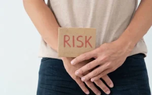 股間の前にRISKと書かれた札を持つ男性