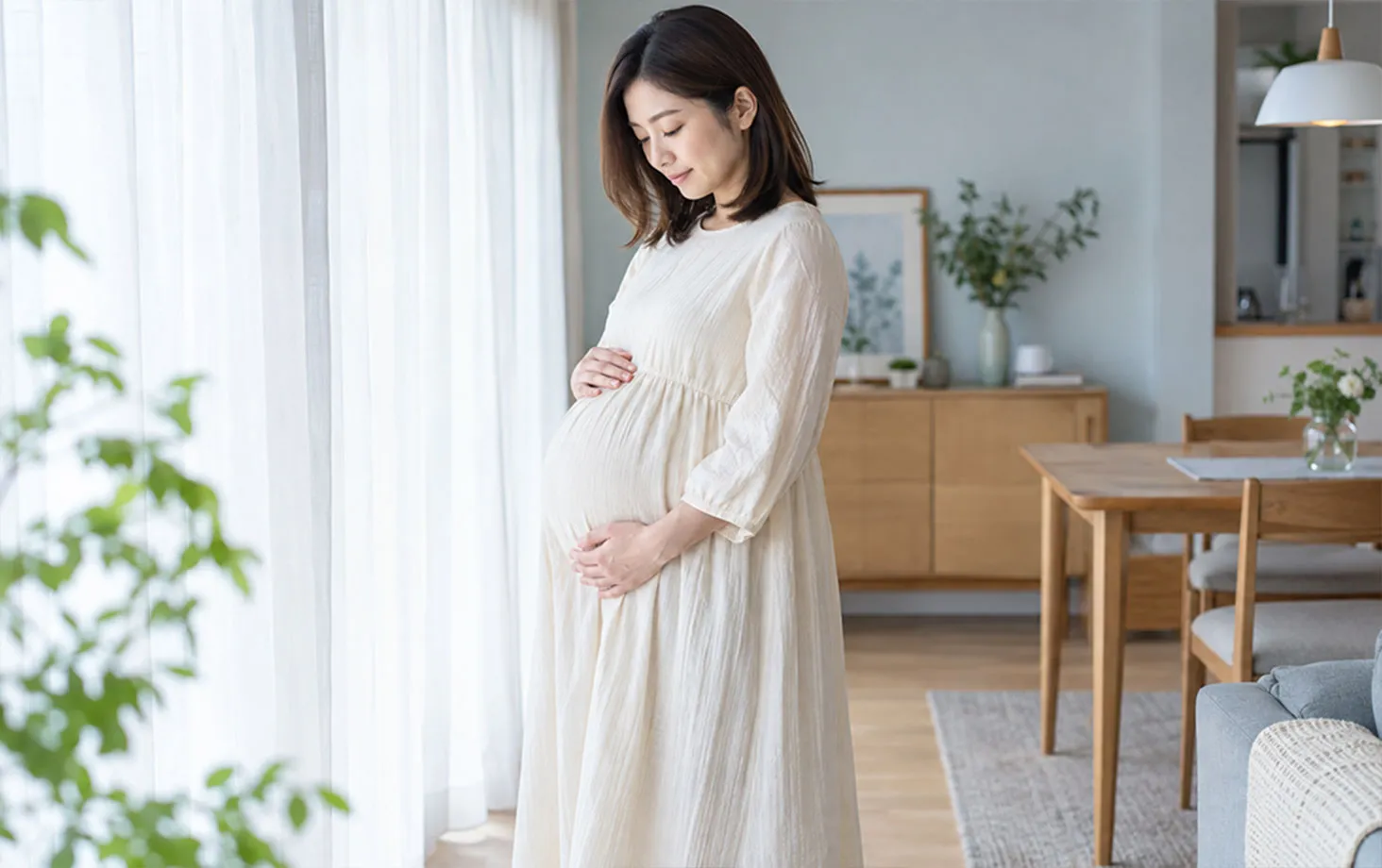 お腹に手を当てて立つ妊婦