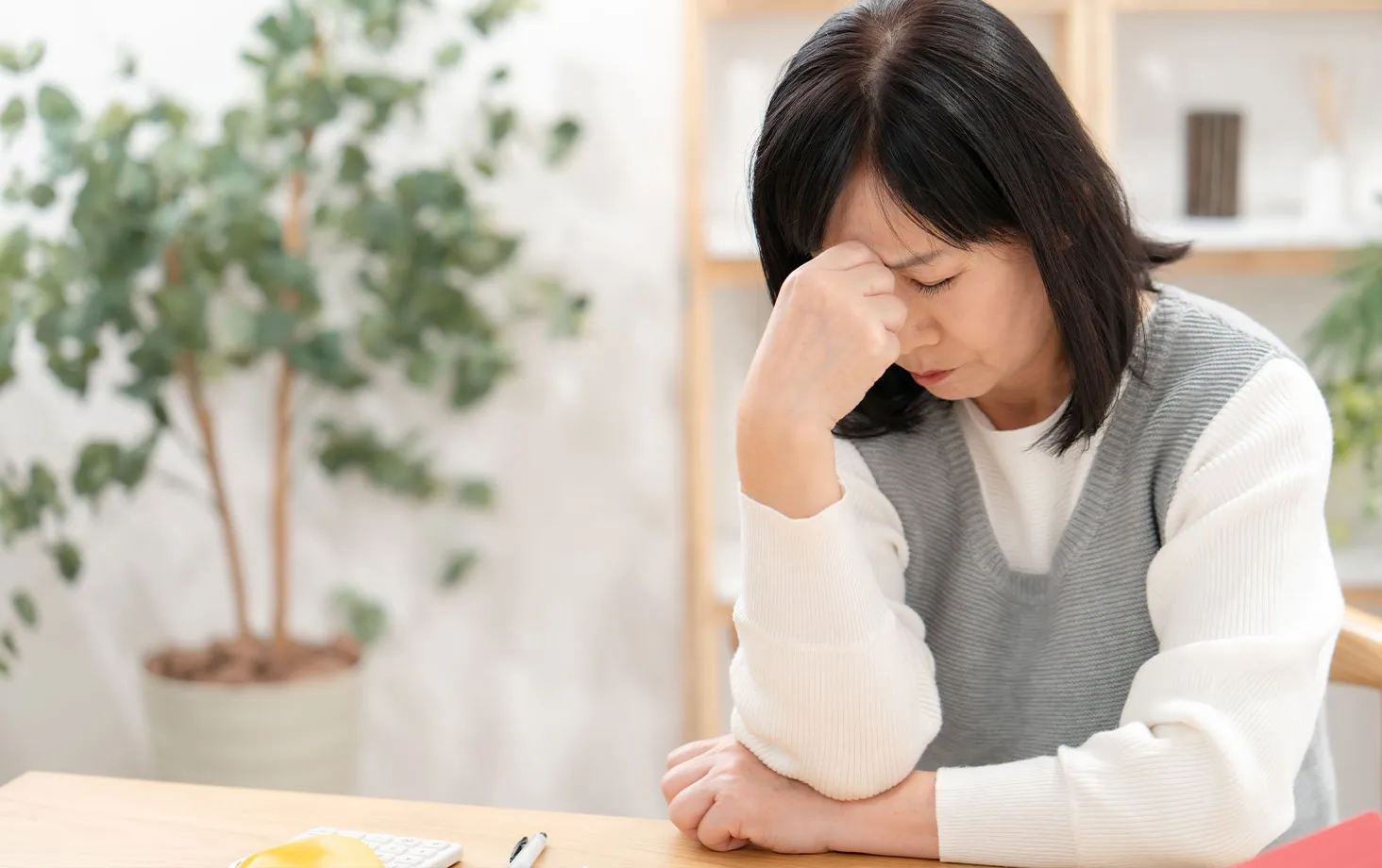 机にうつむく女性